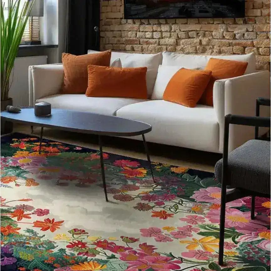 A cozy living room featuring a Radiant Garden Hand Tufted wool rug. This large 8x10 area rug showcases a vibrant floral design, adding a splash of color to the space. Perfect for those seeking living room rugs that combine style and comfort.