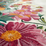 Close-up of a colorful floral patterned rug with pink and orange flowers.