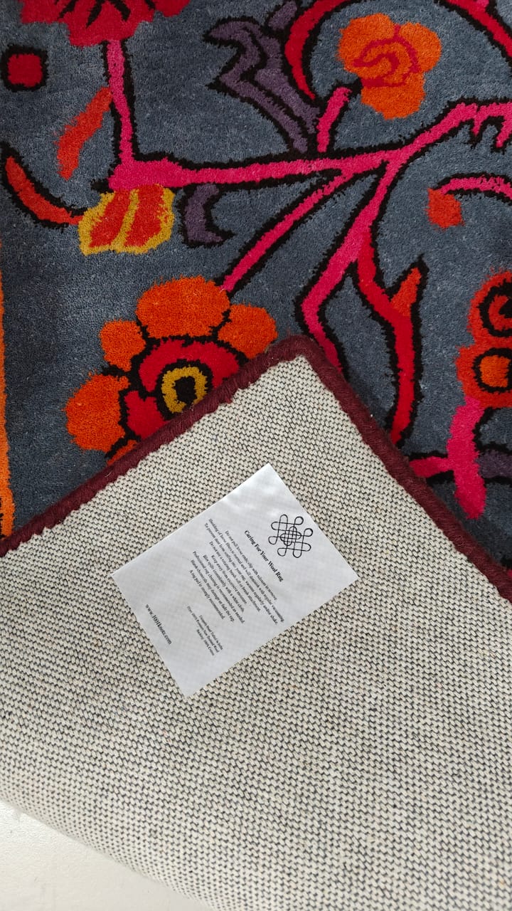 Floral-patterned rug with brand care tag on top
