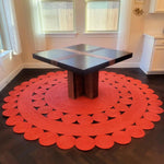 Vibrant red round jute rug adorning a stylish living room setting. This 9x9 area rug features classic circular patterns, perfect for enhancing both living room and bedroom spaces. Ideal for those seeking a unique touch in their home decor.