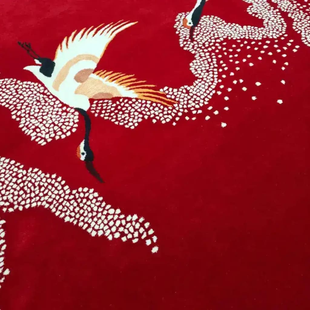 Vibrant red area rug showcasing elegant Japanese cranes in flight across a backdrop of intricate white patterns. Ideal for living rooms or offices, this 8x10 wool rug adds a touch of sophistication to any space, perfect as a centerpiece for a living room or an office setting.