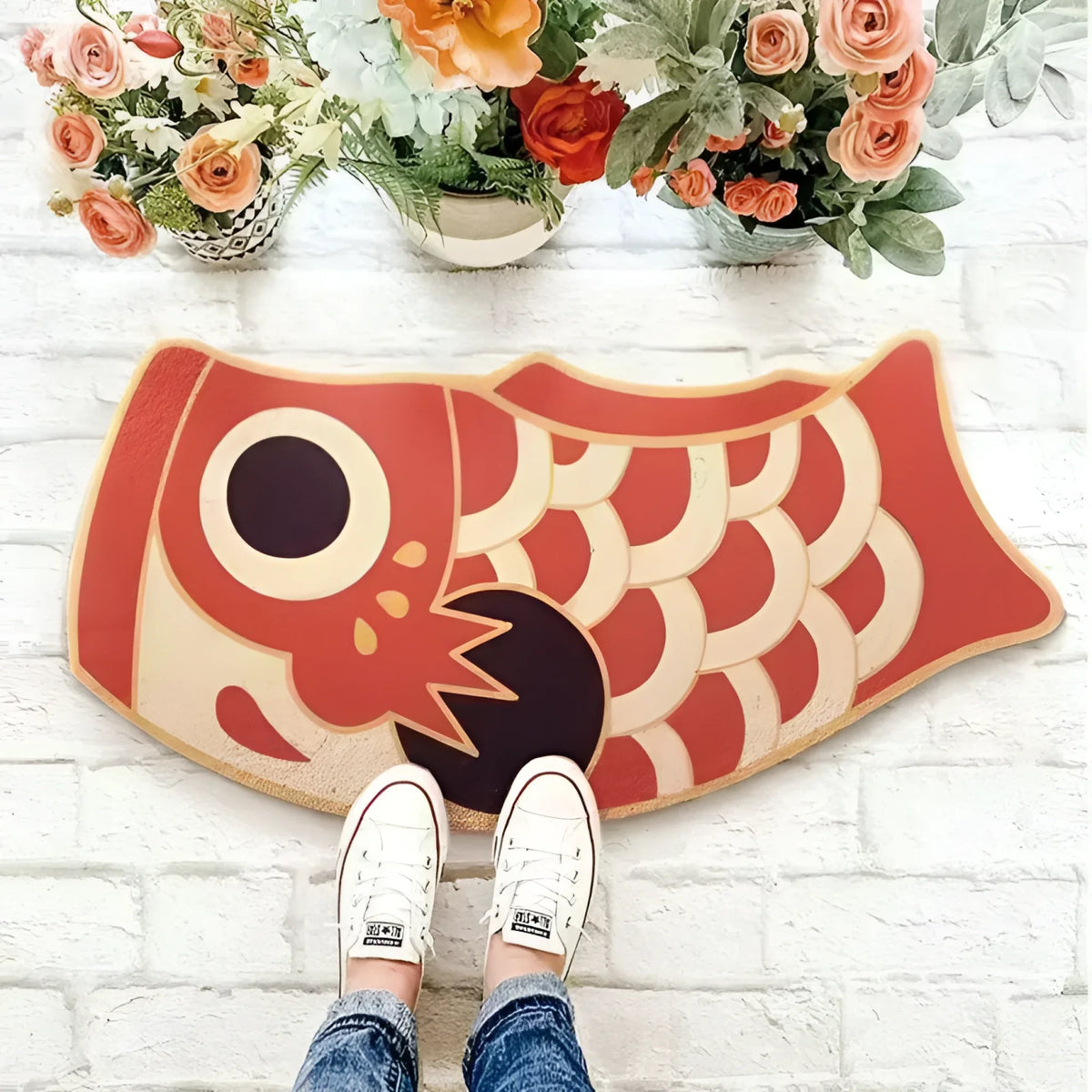 Top view of a vibrant Red Oriental Fish Door Mat placed on a white brick floor surrounded by colorful flowers, perfect for adding a unique touch to living room area rugs. Ideal for those seeking stylish living room rugs 8x10.