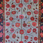 A vibrant Red Velvet Bloom Hand Knotted Area Rug, showcasing a stunning floral pattern with red flowers on a soft blue background. This vintage rug is perfect for adding a touch of elegance to your living room, especially in an 8x10 layout. The intricate design resembles Persian rugs, offering a classic and timeless appeal.