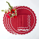 Red & White Delight Placemats fanned flat-lay — solid red oval with white crochet zigzag trim and matching red napkins