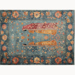 This elegant Regal Conversations Hand Knotted Area Rug showcases a vintage design with a rich tapestry of floral patterns in shades of blue, orange, and red. Perfect for adding a touch of sophistication to any living room area rug collection.