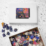 Overhead flat-lay of Regal Eclectic Puzzle white 520-piece box beside open tray overflowing with loose colorful pieces on terrazzo