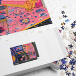 Regal Eclectic Puzzle white box on table with partially assembled puzzle and scattered loose pieces in background