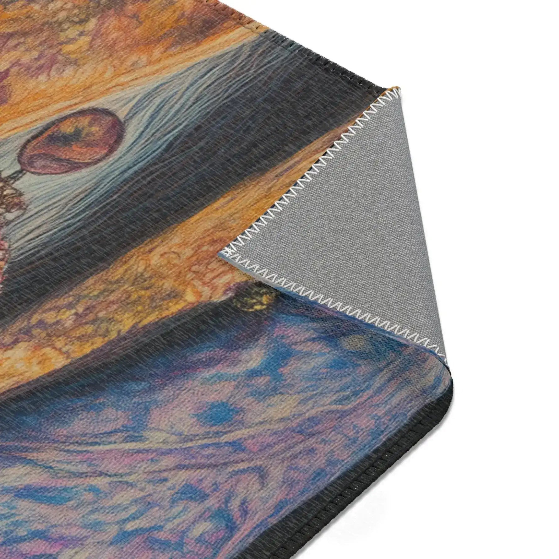 Folded corner of Regal Rebel Couture Monkey Accent Rug showing gold and blue baroque print surface folded over gray non-slip backing with serged edge