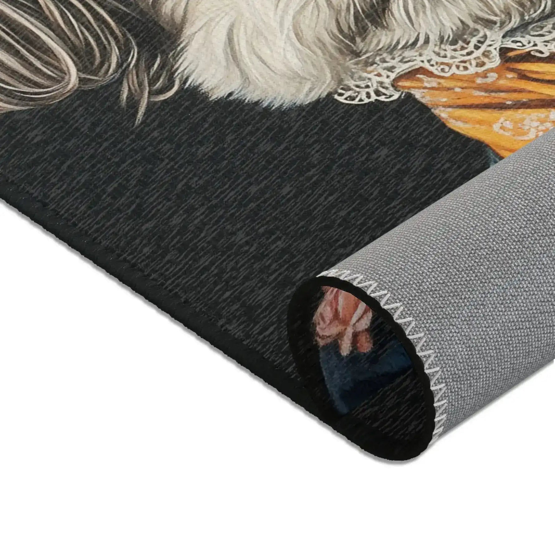 Rolled edge of Regal Renaissance Pup Couture Dog Art Accent Rug showing dark fabric with white dog fur and lace cravat detail and grey backing