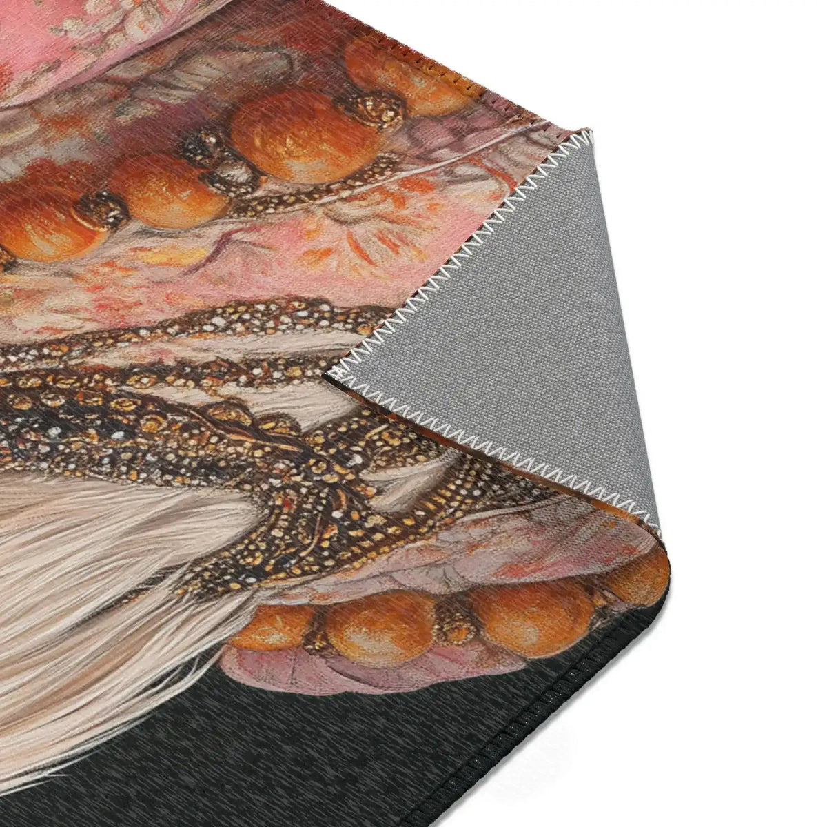 Folded corner of Renaissance Rooster Couture Rug showing rooster costume beaded necklace and floral embroidered fabric detail on dark ground, grey non-slip backing