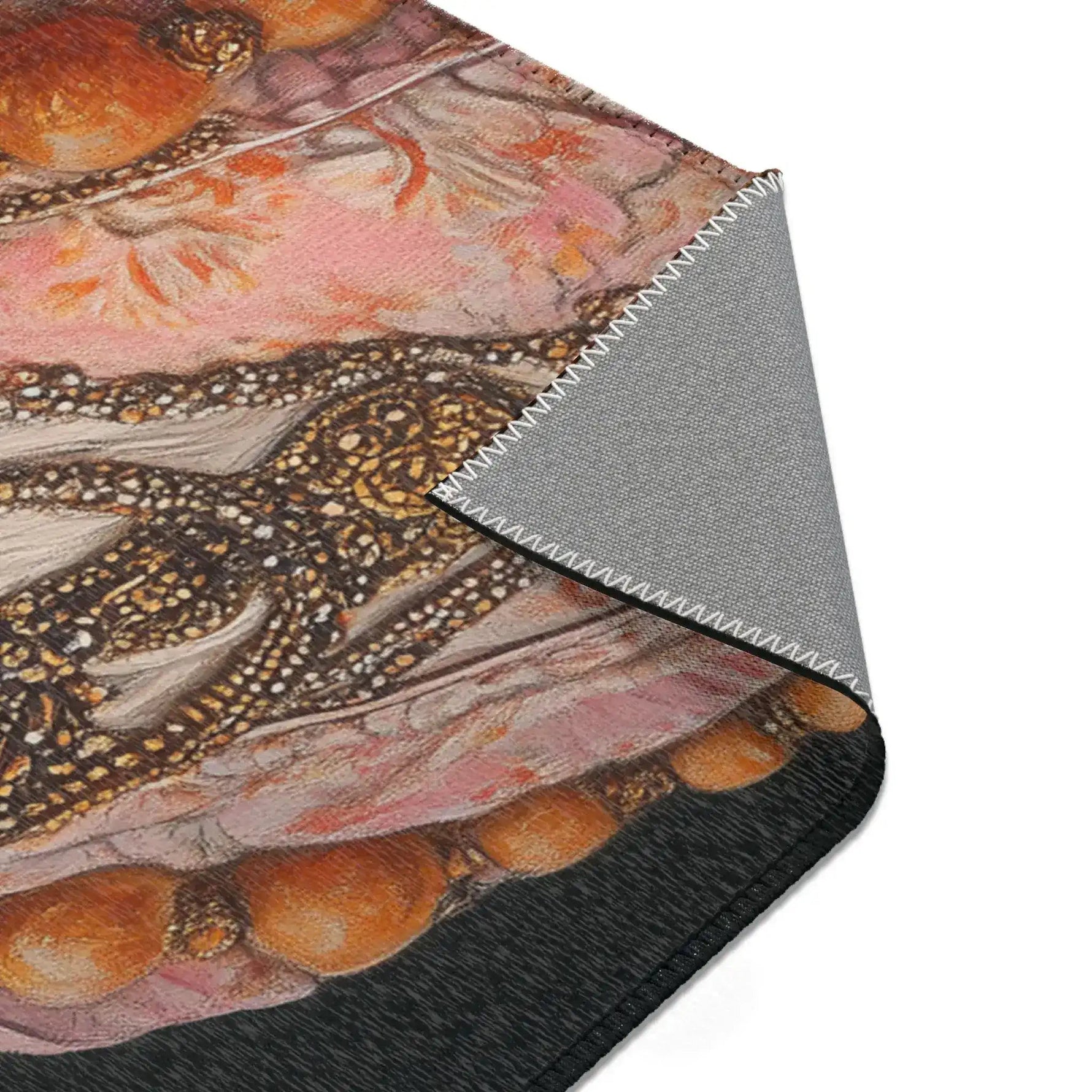Folded corner of Renaissance Rooster Couture Rug showing dark fabric with embroidered rooster costume bead and floral detail, grey non-slip backing at edge
