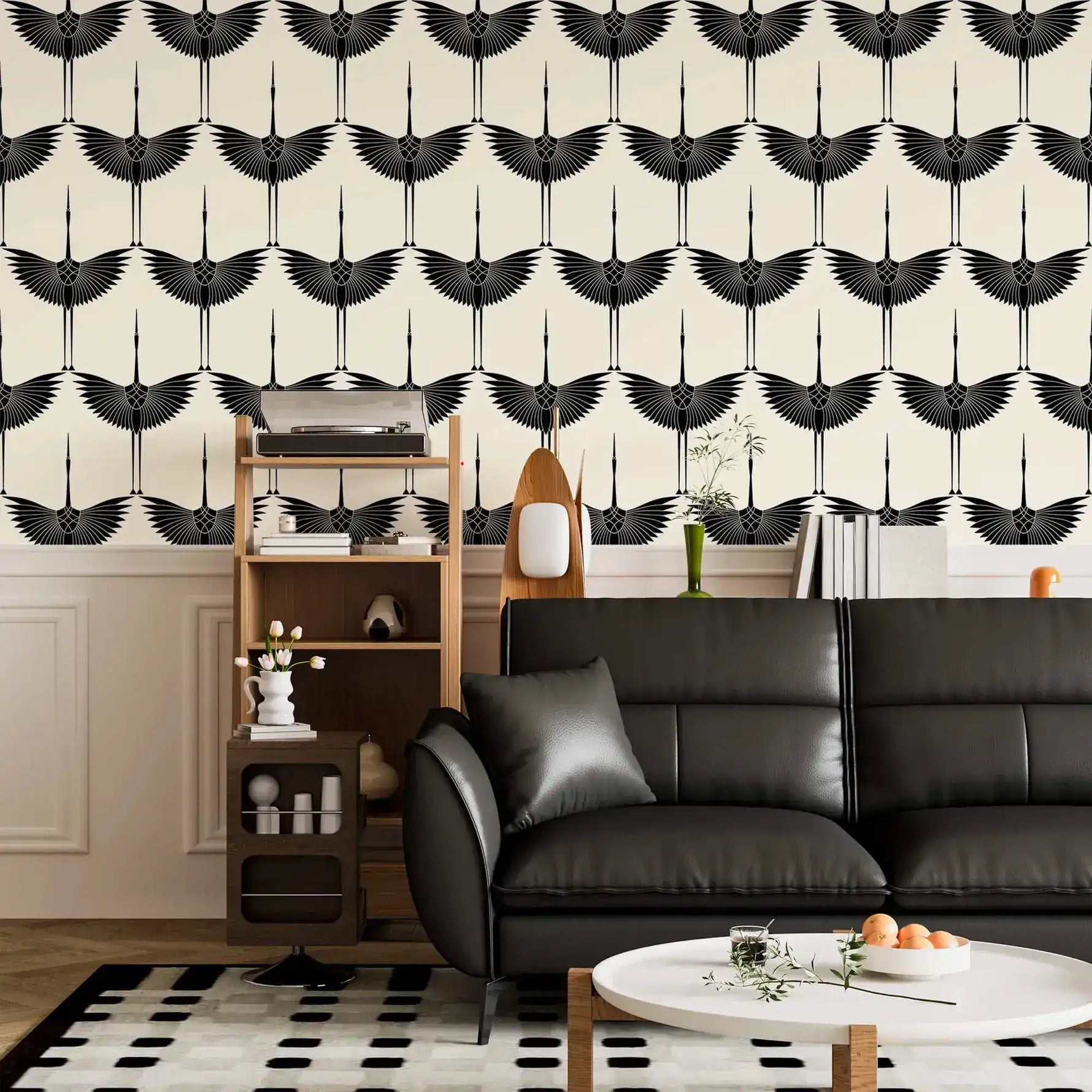 Repeating Black Heron crane wallpaper above wainscoting in a lounge with black leather sofa
