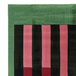 A vibrant, hand-tufted area rug showcasing bold stripes in green, pink, and black, perfect for adding a contemporary touch to any living space. This wool rug is ideal for large living rooms, measuring 8x10, and offers a modern aesthetic with its striking design.