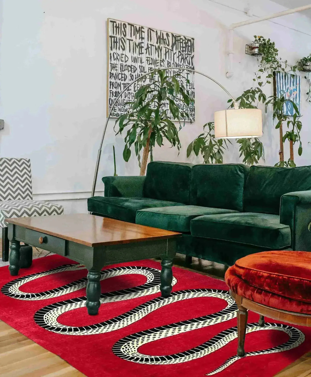 Stylish Retro Red Snake Hand Tufted Wool Rug in a cozy living room setting. The rug adds a vintage charm with its striking snake design, complementing the lush green sofa and wooden coffee table. Ideal for large living rooms or formal dining rooms, this wool area rug brings a touch of elegance and warmth to your home decor.