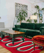Stylish Retro Red Snake Hand Tufted Wool Rug in a cozy living room setting. The rug adds a vintage charm with its striking snake design, complementing the lush green sofa and wooden coffee table. Ideal for large living rooms or formal dining rooms, this wool area rug brings a touch of elegance and warmth to your home decor.