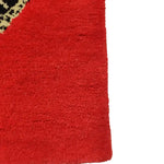 Close-up view of the Retro Red Snake Hand Tufted Wool Rug, showcasing its vibrant red color and intricate snake design. Perfect for adding a vintage touch to dining rooms or large living rooms, this wool rug is an ideal choice for formal dining room settings.