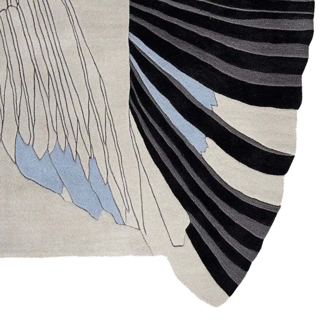 Close-up view of a contemporary area rug featuring an abstract design with flowing black and blue lines on a creamy wool surface, perfect for adding a modern touch to any living room. This 8x10 wool rug is ideal for those seeking stylish and unique rugs for their living space.