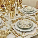 ribboned radiance placemat white gold ribbon bow embroidery gold leaf bowl white plates ornate gold cutlery crystal stemware