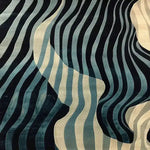 A contemporary area rug featuring a dynamic wave pattern in shades of blue and beige, perfect for adding a stylish touch to any dining room. This wool rug offers an elegant design suitable for both living room and dining room settings, enhancing the ambiance with its modern aesthetic.