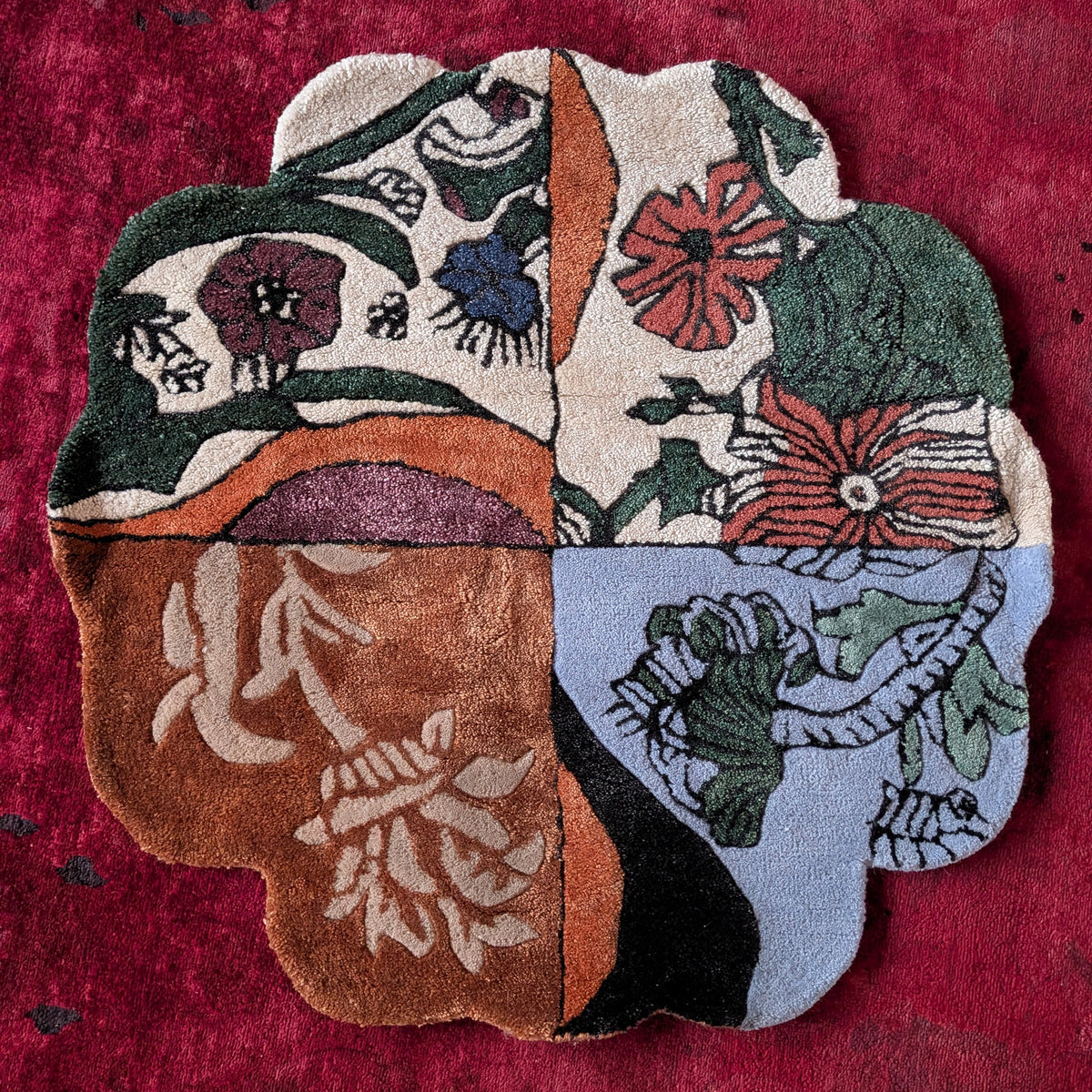 Decorative rug with floral and abstract patterns on a red background