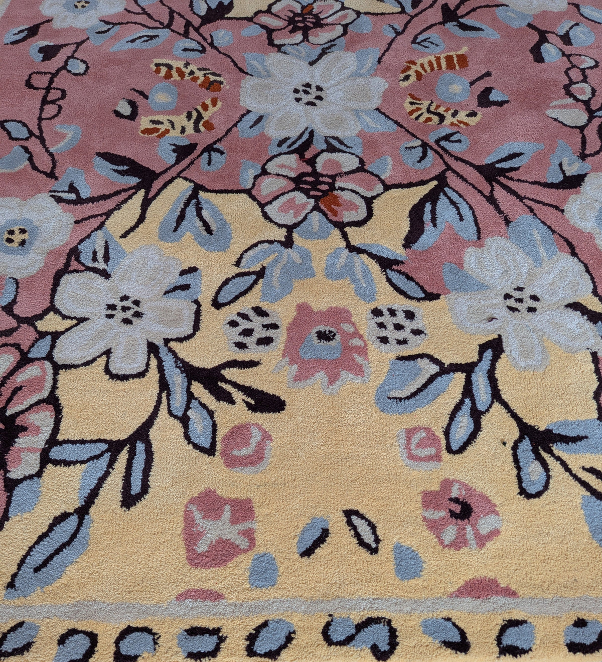 Floral patterned rug with a mix of colors on a yellow background