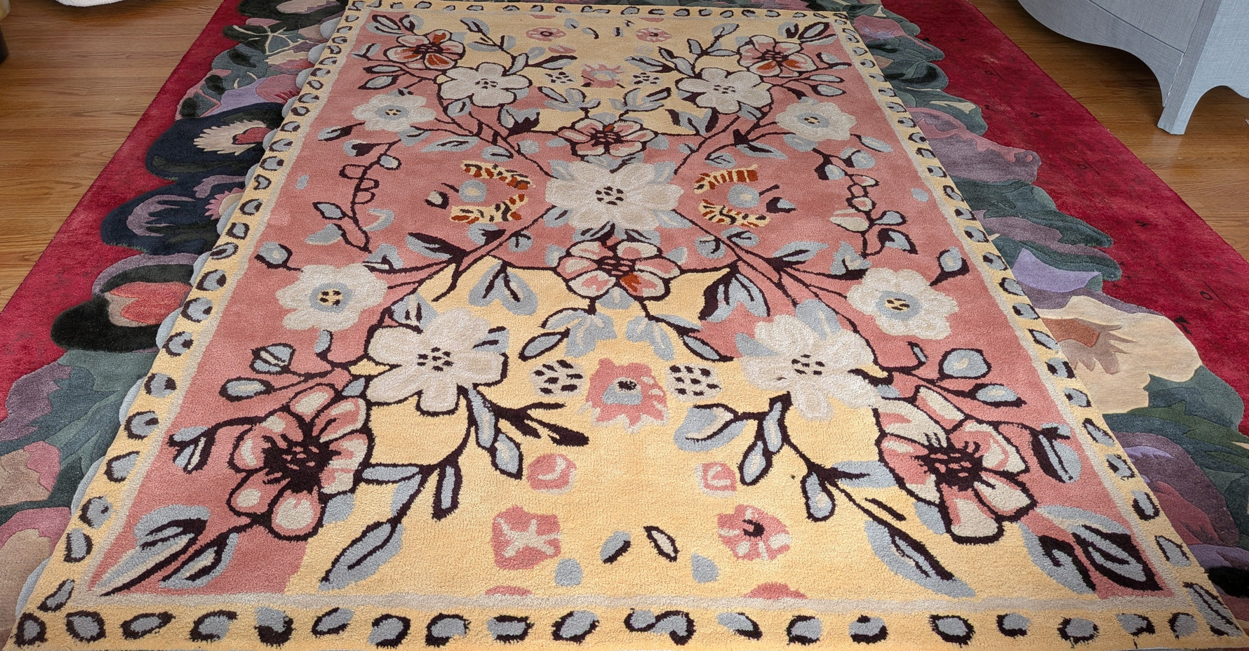 Floral patterned rug on a wooden floor with furniture around