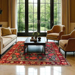 A beautifully designed Roses and Lilies Hand Knotted Area Rug enhances a spacious living room. The large, vintage-style floral rug features vibrant roses and lilies against a dark background, complementing the elegant furniture. This area rug is perfect for adding a touch of Persian charm to any living room.
