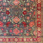 A beautifully detailed hand-knotted area rug featuring an intricate floral pattern of roses and lilies. The vintage design showcases vibrant reds, pinks, and greens on a deep background, ideal for large living rooms. This Persian-inspired floral rug adds a touch of elegance to any space, making it perfect for those seeking a classic area rug for their living room.