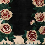 A stunning Rosette Noir hand tufted area rug featuring elegant floral patterns in deep red and cream, set against a rich black background. Perfect for adding a touch of sophistication to your living room or office, this wool rug offers both style and comfort.