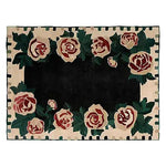 The Rosette Noir Hand Tufted Rug showcases a striking floral design with large roses encircling a deep black center. This elegant area rug, crafted from wool, is perfect for adding a touch of sophistication to living rooms or offices, making it an ideal choice for those seeking floral rugs or wool rugs that enhance any space.