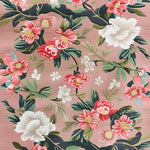 A beautifully detailed Rosy Cascade Hand Tufted Rug featuring an intricate floral pattern with pink and white blossoms spread across a soft pink background. This area rug is perfect for large living rooms, offering a vintage charm with its elegant design. Made from high-quality wool, it adds a touch of sophistication to any living room setting.