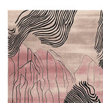 A contemporary area rug showcasing an abstract design inspired by desert landscapes. The hand-tufted wool rug features soft pink and beige tones with bold black lines, ideal for adding a modern touch to living room spaces.