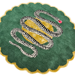 Round green scalloped wool rug with black-and-white snake winding over a golden center and red apple