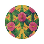 round rug with large pink hibiscus blooms tropical leaves and red cherry clusters on golden yellow background flat view