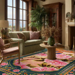 A vibrant Royal Aviary Hand Tufted Area Rug in a living room setting, showcasing a striking floral design with pink and green hues. The wool rug complements the elegant decor, featuring a cozy sofa, armchair, and a round wooden coffee table. Perfect for both dining room and living room, this floral rug adds a touch of nature-inspired beauty to any space.