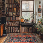 Cozy living room featuring a Royal Blossom Hand Knotted Area Rug with vintage floral patterns. This Persian rug adds warmth and elegance to the room, surrounded by bookshelves and plants.