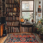 Cozy living room featuring a Royal Blossom Hand Knotted Area Rug with vintage floral patterns. This Persian rug adds warmth and elegance to the room, surrounded by bookshelves and plants.
