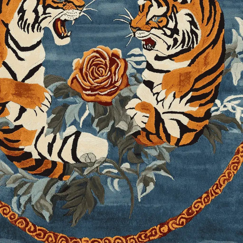A vibrant hand-tufted area rug featuring two fierce tigers facing each other over a large, detailed rose on a deep blue background. This wool rug showcases a vintage floral design with intricate details, perfect for adding a touch of elegance to living room spaces. Ideal as an 8x10 living room area rug, blending the charm of a floral rug with the timeless appeal of a vintage rug.