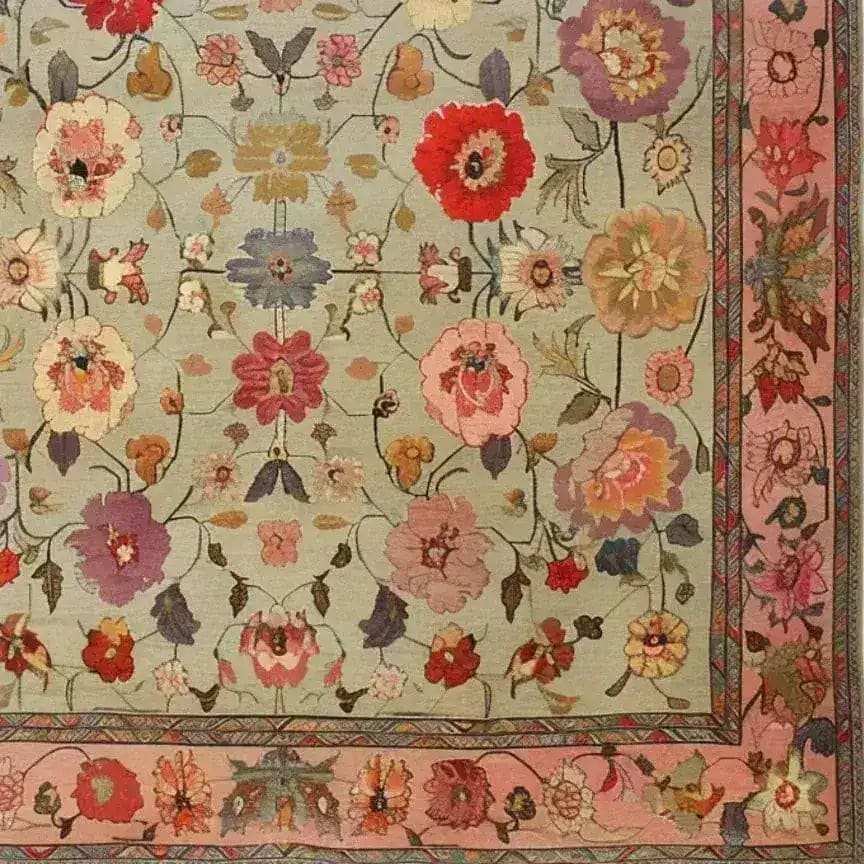 A beautifully detailed Royal Elegance Hand Knotted Area Rug featuring a vibrant floral design. This square area rug showcases intricate vintage patterns with colorful flowers spread across a wool surface, perfect for adding a touch of elegance to a living room or bedroom. The Persian-inspired design makes it a luxurious addition to any large living room, combining style and comfort.