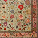 A beautifully detailed Royal Elegance Hand Knotted Area Rug featuring a vibrant floral design. This square area rug showcases intricate vintage patterns with colorful flowers spread across a wool surface, perfect for adding a touch of elegance to a living room or bedroom. The Persian-inspired design makes it a luxurious addition to any large living room, combining style and comfort.