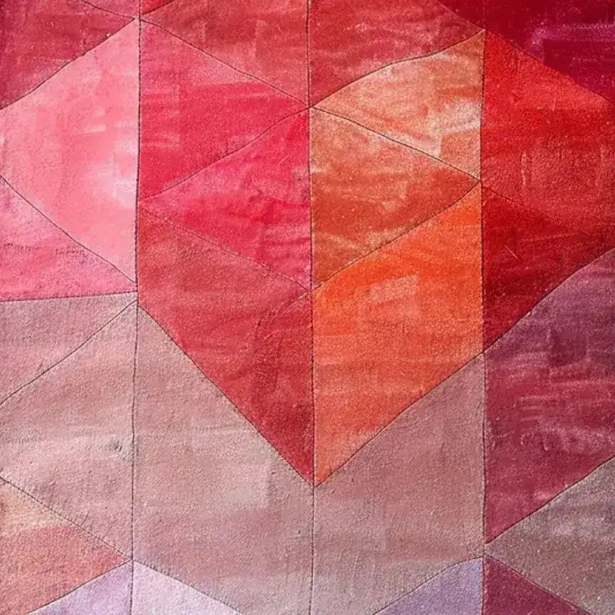 Vibrantly colored Ruby Rhapsody Wool Runner Rug showcasing an abstract geometric pattern in shades of red, pink, and orange. Perfect as an area rug for a contemporary living room or formal dining room, this wool rug brings warmth and style to any space, be it a kitchen, hallway, or bathroom runner.