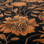 Close-up of a textured fabric with floral patterns in brown and black.
