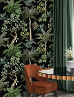 Rust velvet chair and green curtain beside jungle foliage wallpaper of tropical palms on black