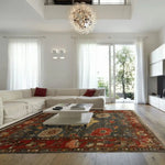 A beautifully designed Rustic Elegance Hand Knotted Area Rug graces a modern living room. The vintage Persian floral rug features rich red and earthy tones, complementing the minimalist decor and white sectional sofa. Perfect for enhancing rugs for living room aesthetics.