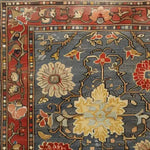 A close-up view of a Rustic Elegance Hand Knotted Area Rug, showcasing intricate floral patterns in rich shades of red, blue, and yellow. This vintage rug design adds a touch of elegance to any living room, reminiscent of classic Persian rugs.