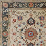 Close-up view of a rustic floral design hand-knotted area rug featuring intricate patterns and vibrant colors. This vintage rug showcases a beautiful arrangement of traditional motifs, making it perfect for large living room spaces. Ideal as a living room area rug, this Persian-inspired floral rug brings a touch of timeless elegance to any home.