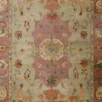 This image showcases a beautifully crafted Rustic Heritage Hand Knotted Area Rug, featuring intricate vintage patterns with floral and geometric designs in soft, earthy tones. Ideal for adding a touch of elegance to your living room, this Persian-inspired rug combines traditional artistry with modern charm, making it a perfect centerpiece for any space.