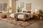 Cozy bedroom with wooden bed, patterned rug, and decorative elements.