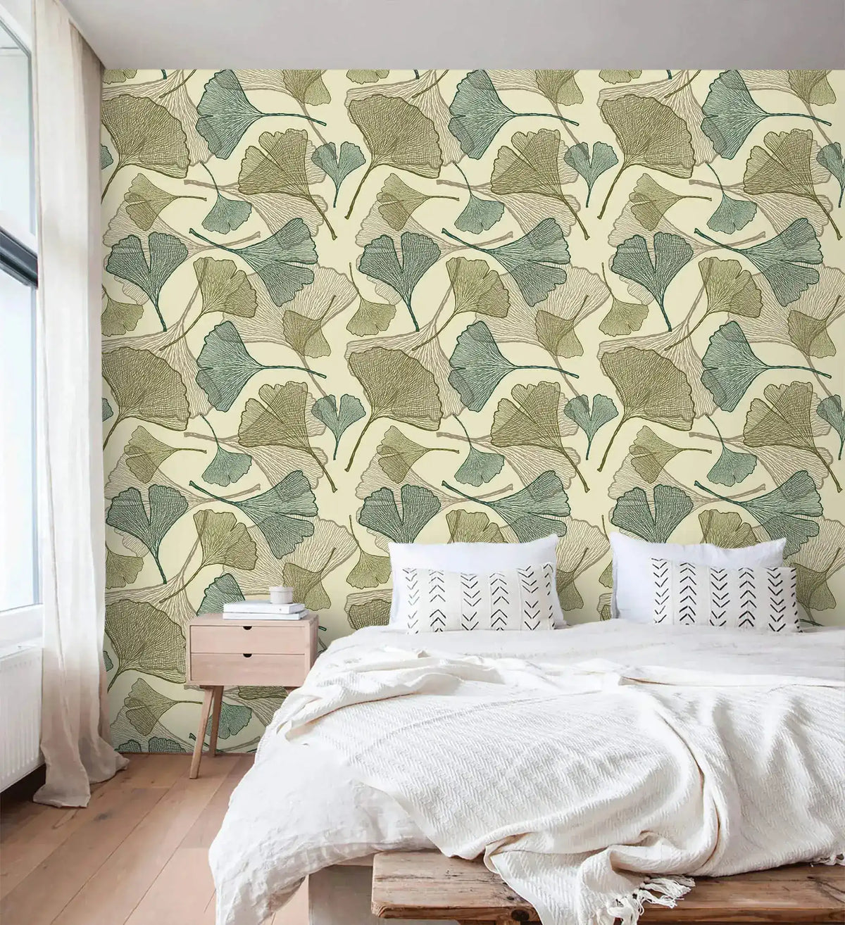Sage and beige ginkgo leaf wallpaper in bedroom with white bedding and wood nightstand