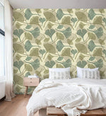 Sage and beige ginkgo leaf wallpaper in bedroom with white bedding and wood nightstand